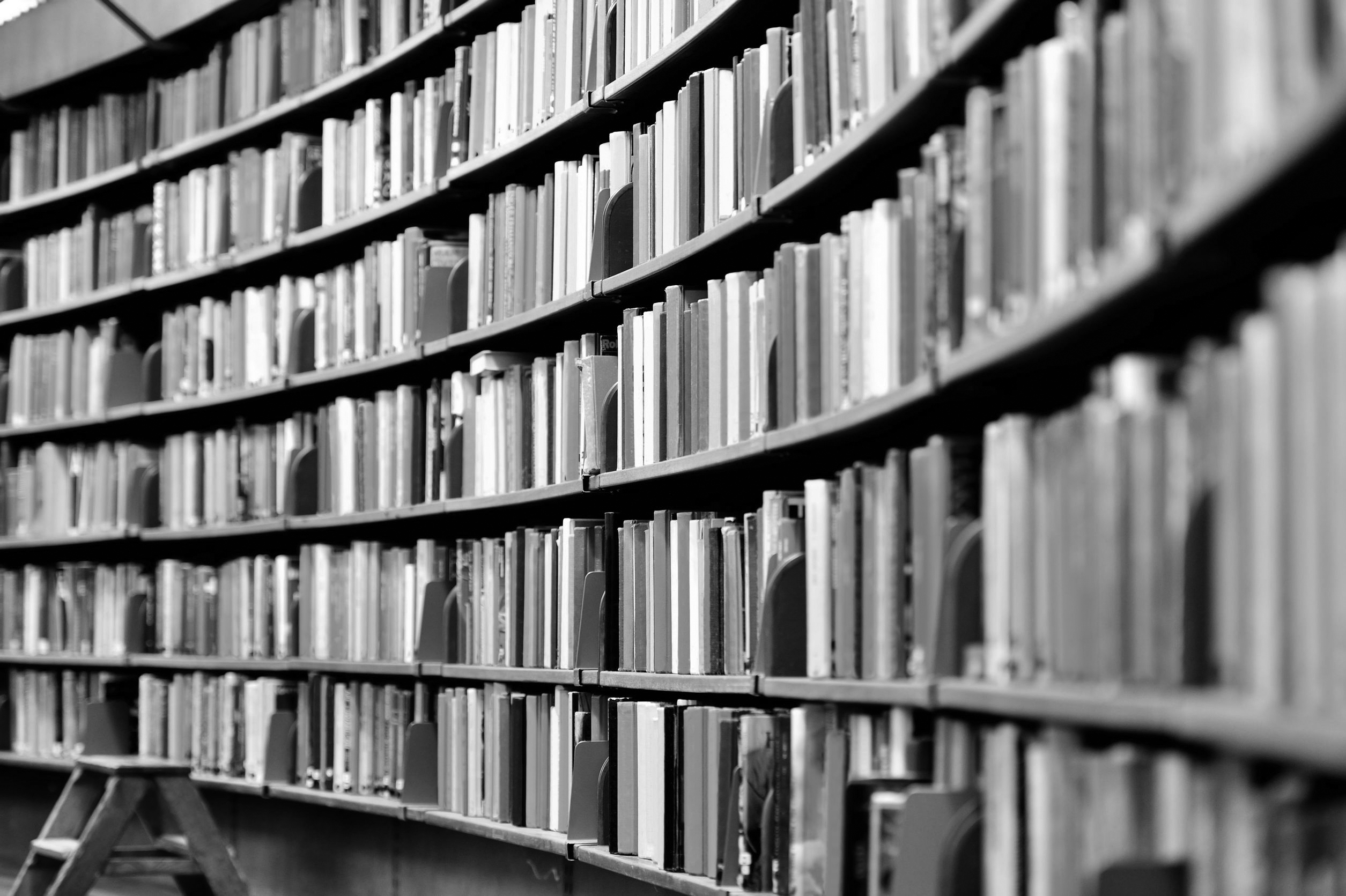Black and white image of shelves of books.