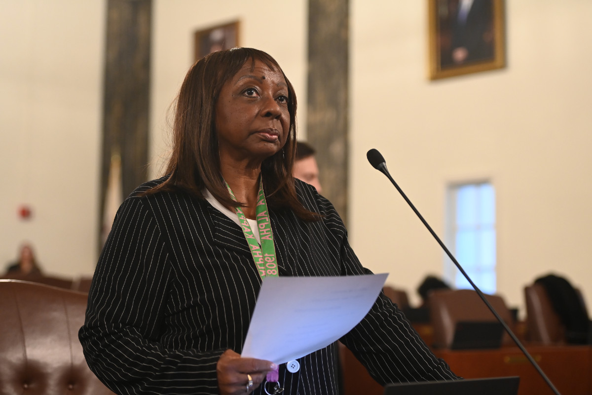 Senator Hunter holds a piece of paper and stands in front of a microphone on the Senate floor.