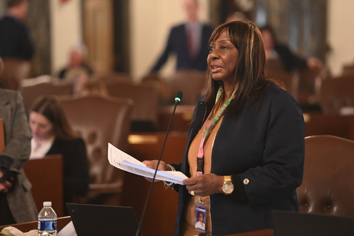 Senator Hunter holds a piece of paper while speaking into a microphone on the Senate floor.