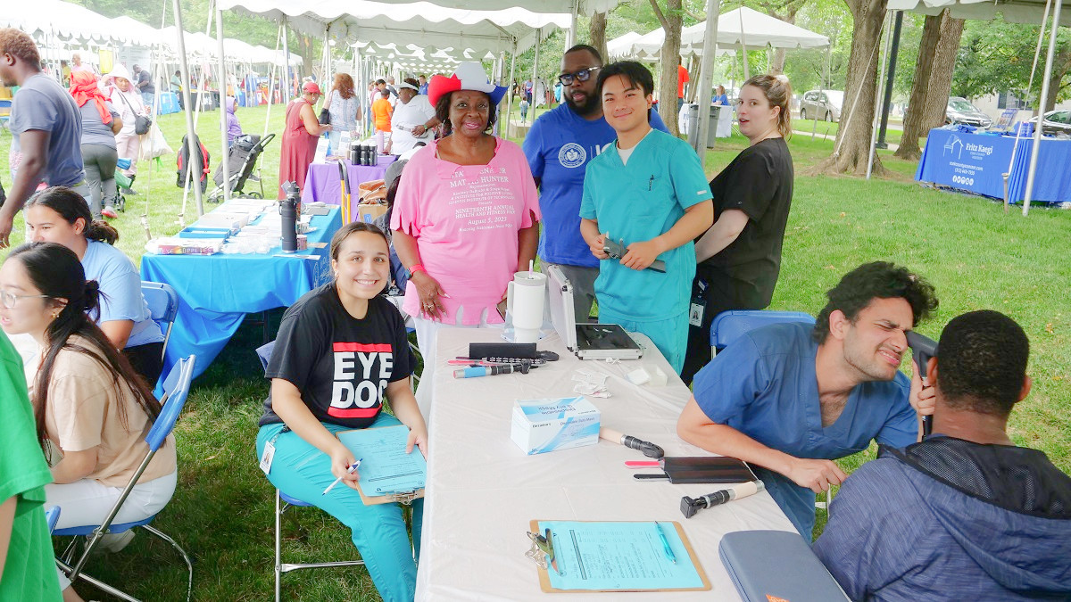 Senator Hunter poses with health professionals giving eye exams at the fair.