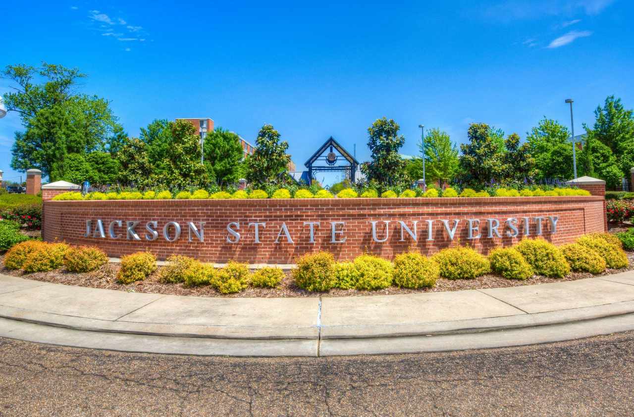 A curved brick outdoor entrance sign with Jackson State University on it.