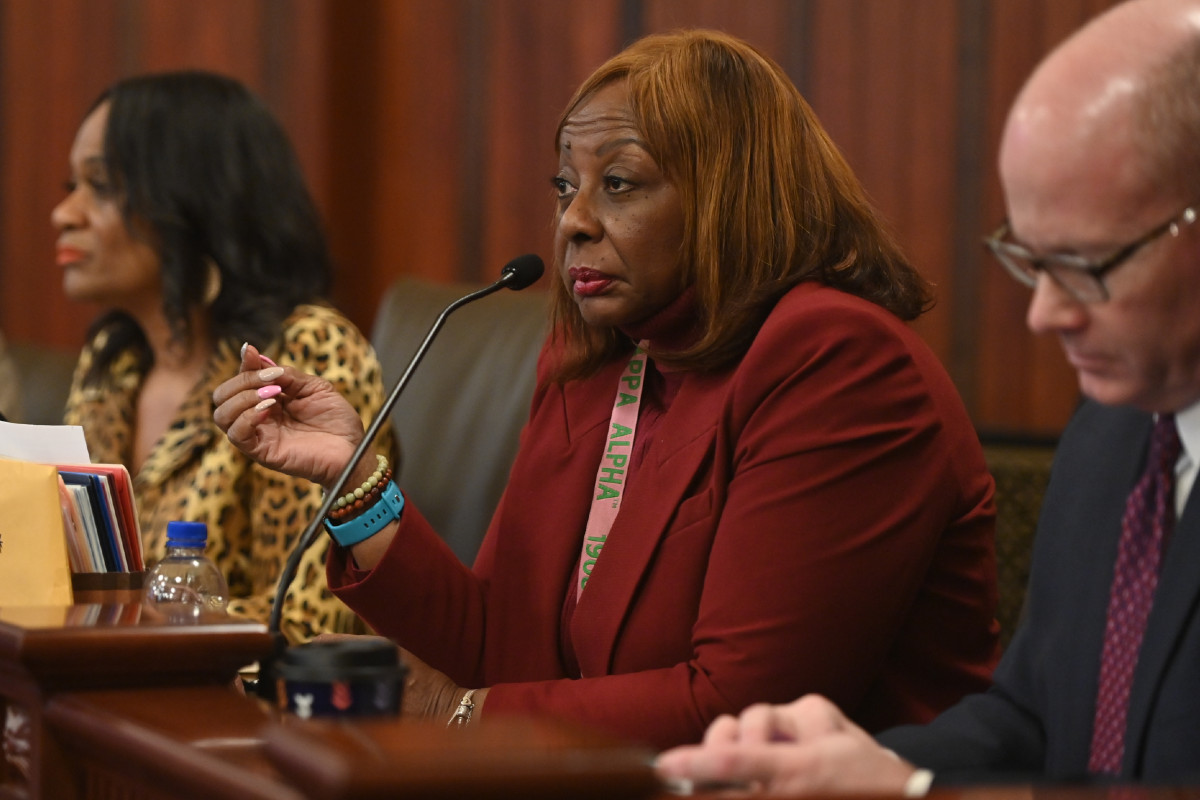 Senator Hunter sits in front of a microphone during a committee hearing.